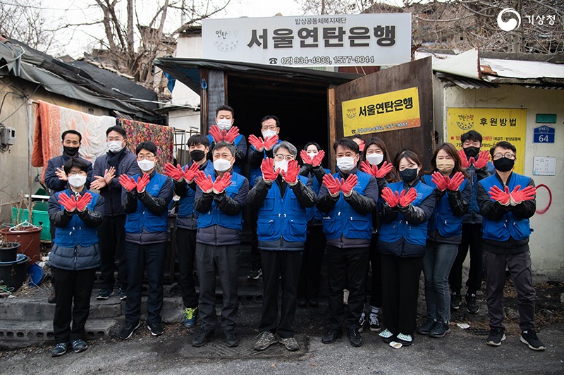 유희동 기상청장과 기상청 직원 및 서울연탄은행 관계자들이 연탄 배달 전 단체사진 포즈를 취하는 모습