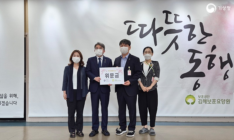 유희동 기상청장이 김해보훈요양원에 위문금을 전달하고 관계자와 기념촬영하는 모습